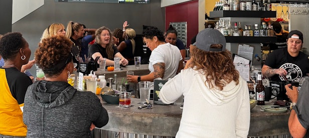 People sit at the bar and watch sports games on the tvs at Watch Me! Sports Bar